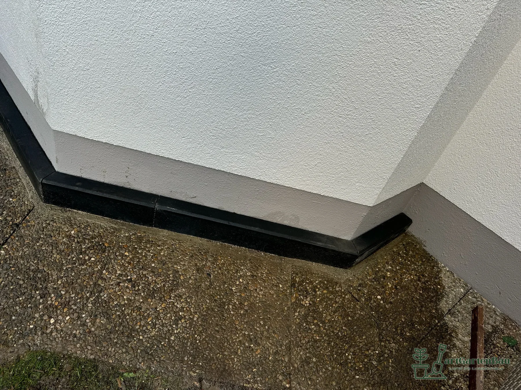 Sockelanschluss mit Kiesstreifen an einer Hauswand