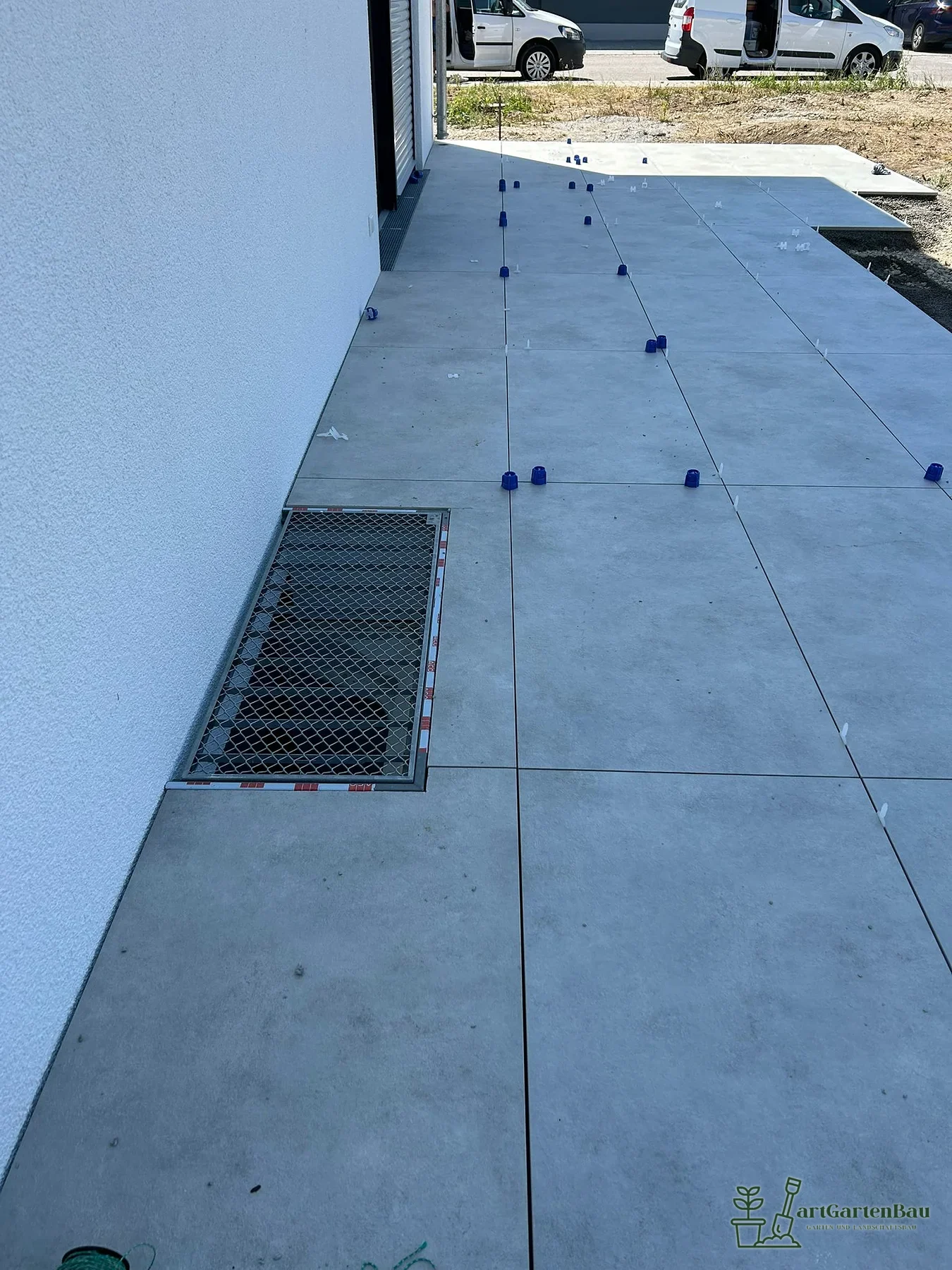 Hofbereich mit Betonplatten und Entwässerungsrinne