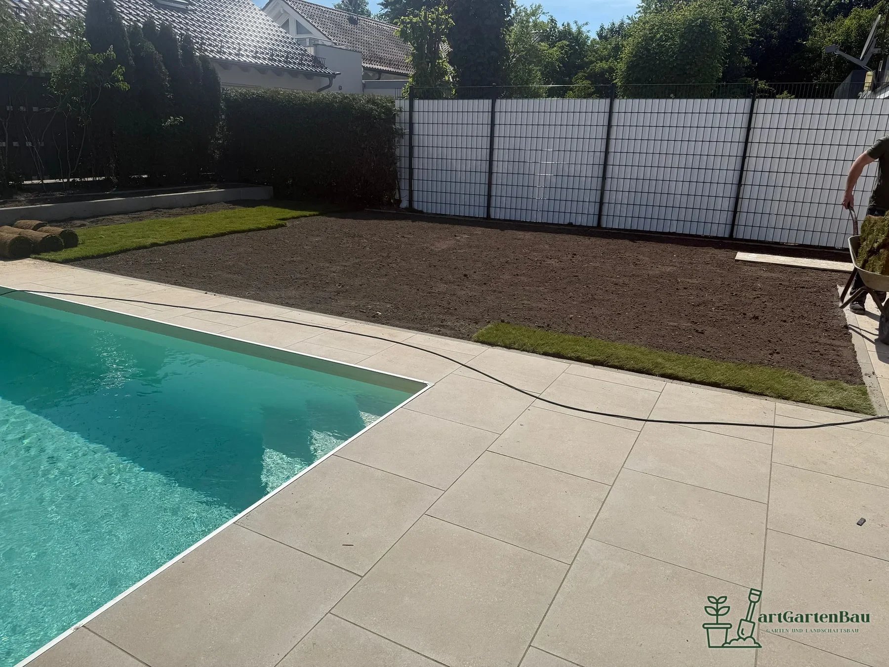 Helle Poolterrasse mit Gartenfläche und Sichtschutz