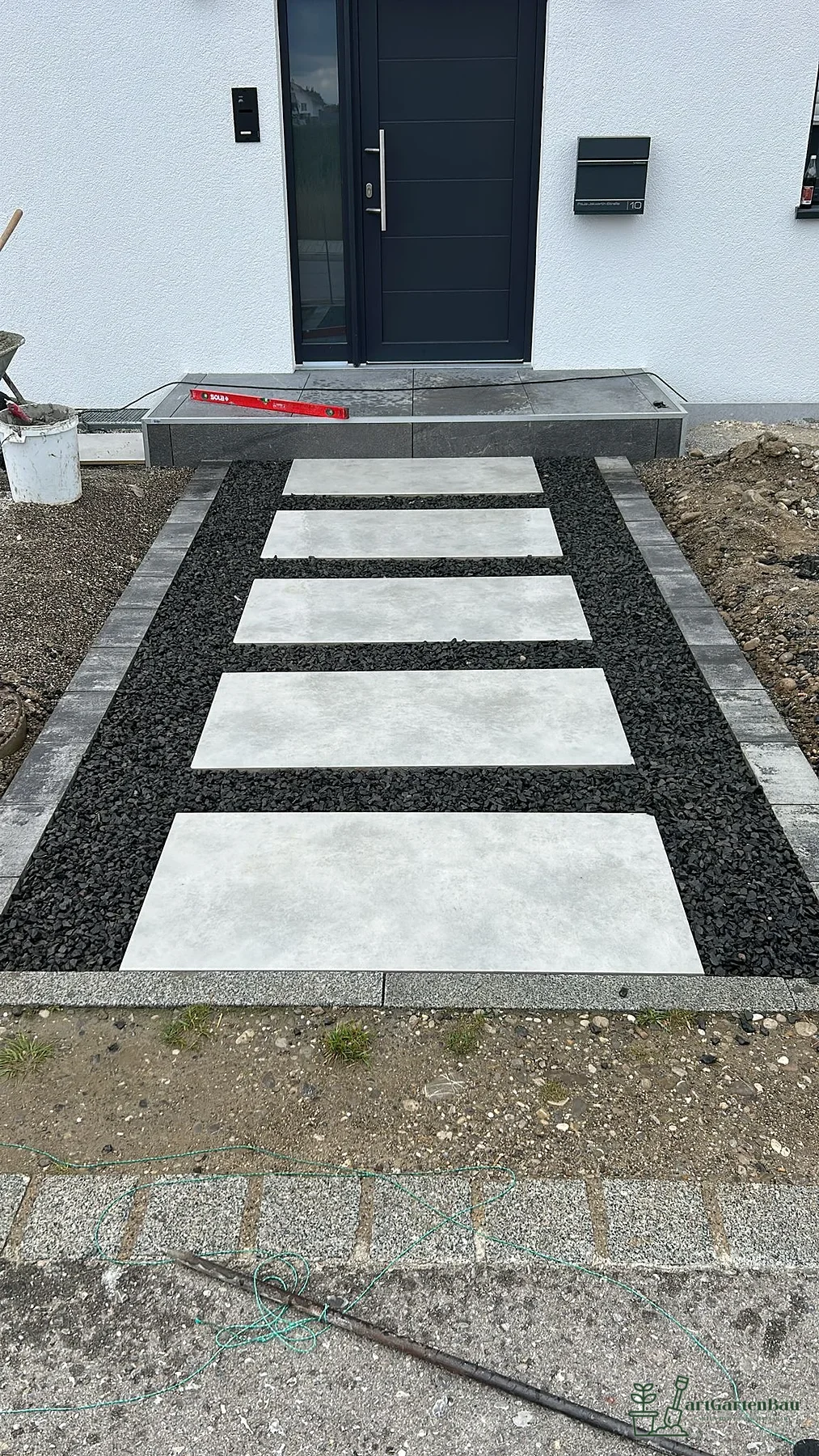 Moderner Hauszugang mit Platten und dunklem Kiesstreifen in Bad Wörishofen