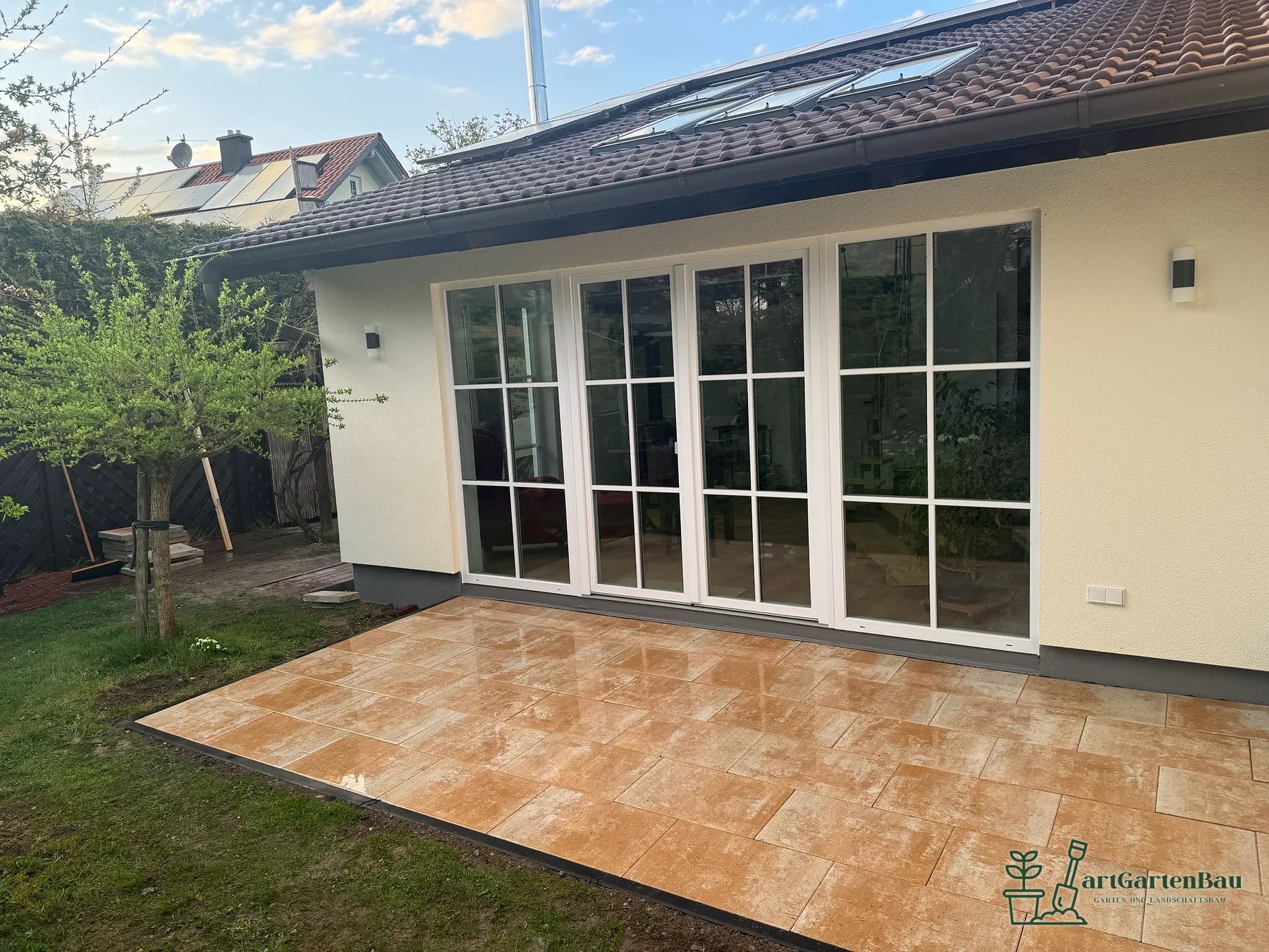 Terrasse mit warmen Terracotta-Fliesen vor Glasfront